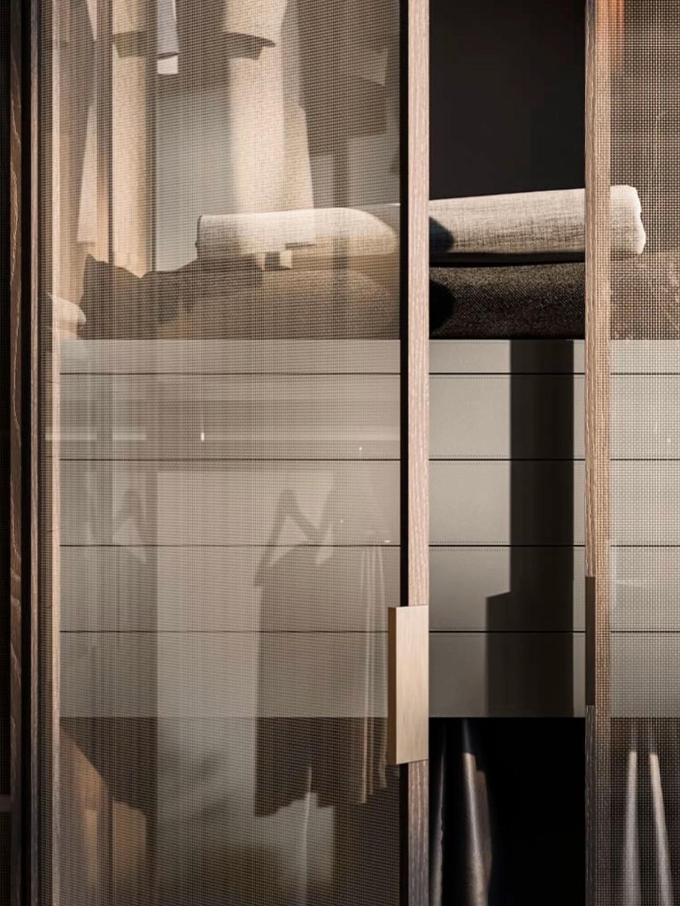Dressing sur mesure avec portes coulissantes en verre mesh et cadre bois foncé, poignée laiton, rangement haut de gamme